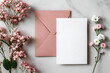 © john - Minimal composition with a pink envelope, white blank card and a wax flower on a white background. Mockup with envelope and blank card. Flat lay. Top view.