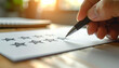 © Athiphat - Hand holding pen drawing empty stars on paper feedback form, sunlight in background, concept of rating, review, evaluation, customer satisfaction, and quality assessment in calm atmosphere