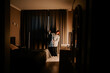 © Darius - Young woman ironing a shirt in a room with curtains and furniture in the evening light