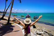 © zigres - Young woman with open arms dreaming to explore with a raft the natural swimming pools of Ponta Verde, Maceio, Brazil