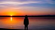 © Gandi - Child Silhouetted Against a Vibrant Sunset Over a Calm Lake.