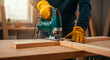 © ivan canavera - Worker using electric jigsaw to cut wooden boards in carpentry workshop