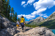 © unai - Tourists hiking along lake minnewanka in banff national park, alberta
