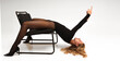 © Maxim Chuev - Young charming lady girl laying on chair in black bodysuit, nylon tights pantyhose and shoes with high heels. Caucasian photo model female woman at work posing in studio Isolated on white background.