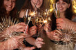 © New Africa - Friends with glasses of sparkling wine and sparklers celebrating New Year, closeup
