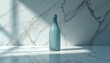 © Pete - Frosted blue bottle rests on marble surface. Soft window light casts sharp shadows. Minimalist scene suggests beverage, decor, or beauty product.