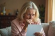 © Pete - Worried elderly woman reads paper document at home. Senior lady expresses distress, concern, sadness after getting bad news. Mature person with upset face sits alone, holding mail.