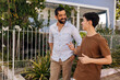 © kleberpicui - Father and teenage son smile while talking during a walk in a small residential neighborhood, showing connection, communication, emotional balance, and a healthy family relationship