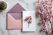 © Daniel - Minimal composition with a pink envelope, white blank card and a wax flower on a white background. Mockup with envelope and blank card. Flat lay. Top view.