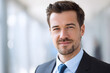 © Vladimir - professional headshot of corporate executive in modern office interior, looking at camera and smiling, soft blurred office background