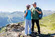 © Elena Medoks - Hikers standing on mountain top enjoying scenic view