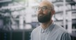 © Framestock - Focused IT Manager Supervising Modern Server Infrastructure. Bearded Male With Glasses and ID Badge Supervising Vast, Infrastructure of Data Center. Technology and Professional Oversight. Portrait.