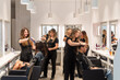 © Juanma Cuevas - Hairdressers styling client hair in modern salon