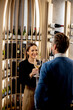 © BGStock72 - Couple enjoys wine tasting in a modern bar with shelves filled with bottles