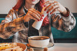 © EdNurg - Woman's hands using a salt grinder to season a bowl of soup, adding flavor to her meal at a restaurant establishment