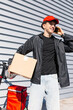 © ADDICTIVE STOCK - Young delivery boy on an electric scooter with a package