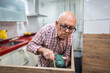 © ADDICTIVE STOCK - Active senior engaged in home kitchen renovation