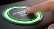 © abu - Close up of a finger pressing an 'Autonomous Drive Start' button with a green ring on a black console, illustrating futuristic vehicle technology.