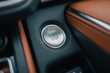 © MdSahab - Close up of a modern car engine start stop button on a leather dashboard, automotive technology