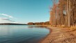 © AkuAku - Lakeside setting with long-shadowed trees and clear blue sky, highlighting shoreline ecology