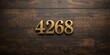 © pngking - Gold-painted wooden Arabic numerals 4268 displayed on a dark brown and white patterned plank surface, used for signage or labeling