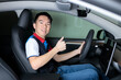 © fotolite - An Asian teenager gives a thumbs up while sitting in the driver's seat with hand on the steering wheel, ideal for teen driving safety, first car, or driver education concepts.