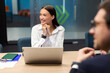 © Home-stock - Cheerful businesspeople listening presentation in office boardroom, business professionals sitting with laptops at table and looking aside