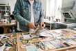 © Meow Creations - Creative artist cutting magazine images with scissors to build a mood board in a bright studio