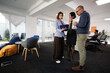 © Nikola Spasenoski - Experienced business professionals collaborate in a modern office space during a strategy meeting focused on project development and team dynamics