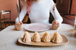 © EdNurg - Woman poised with fork and knife over steaming plate of fresh khinkali dumplings in cozy Georgian restaurant, ready to eat