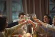 © Lustre Art Group  - Group of people raising wine glasses for toast during home dinner. Concept of festive dining, wine brand campaigns, holiday marketing, hospitality promotion, and social event advertising.