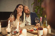 © Lustre Art Group  - Couple sharing warm moment at wine dinner with friends. Concept of Valentine Day celebration, emotional connection, romantic storytelling and lifestyle brand communication.