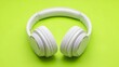 © Sadik - A pair of white headphones on a bright green background