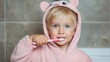© Iryna - Little child brushes teeth in soft pink bear pajamas in bathroom during morning routine
