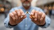 © Gulnaz - A man holding two cigarettes in his hands, one of which is already burnt