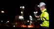 © reewungjunerr - Industrial engineer night inspection at refinery or petrochemical plant walkie-talkie hand and digital tablet intersection of technology, worker work at night at power plant