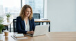 © MYDAYcontent - Woman works on laptop at desk in modern office during the day.