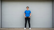 © MyDigitalCraft - person in blue shirt and jeans standing against a gray garage door
