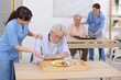 © New Africa - Care worker serving dinner and comforting senior man at retirement home