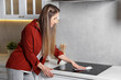 © New Africa - Woman wiping cooktop with paper towel in kitchen, space for text