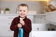© New Africa - Child safety at home. Little boy with bottle of cleaning product in kitchen, space for text