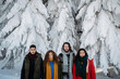 © Halfpoint - Portrait of friends in front of snow covered trees in winter nature.