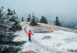 © Soloviova Liudmyla - Lonely woman dressed in bright red waterproof jacket with backpack and trekking poles, taking last steps climbing Minchol summit 1364m in Mala Fatra mountain range, Slovak Republic.