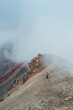 © Soloviova Liudmyla - Lonely female backpacker dressed rain cover with backpack and trekking poles making acclimatization trek around Lenin peak base camp climbing Petrovsky Peak 4910 m, Pamir mountains range, Kyrgyzstan.