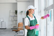 © Pixel-Shot - Female janitor with squeegee cleaning window in office