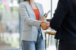 © David - Two businesspeople shaking hands after a deal contract is done.