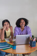© Hector Pertuz - Young women studying together using laptop for e-learning