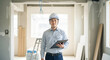 © Y Creative Stock - 建設現場でクリップボードを持ち微笑む若い日本人男性の施工管理スタッフ、作業着とヘルメット、室内リフォーム工事、内装工事、生成AI