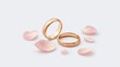 © Nami Liu - A romantic scene with pink rose petals and a pair of golden wedding rings placed on a white background.