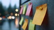 © Thares2020 - Colorful sticky notes with water droplets on a dark surface against a blurred twilight city background